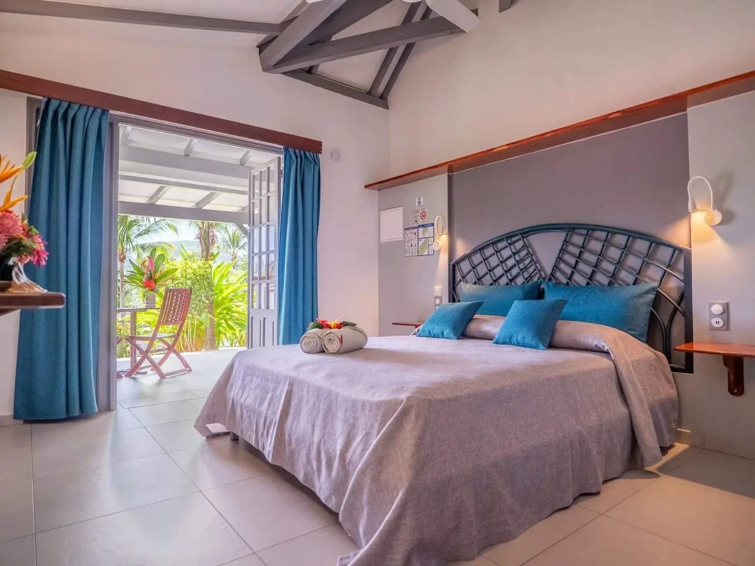 http://Chambre%20climatisée%20avec%20grand%20lit,%20terrasse%20privée%20et%20vue%20sur%20un%20jardin%20tropical%20luxuriant.