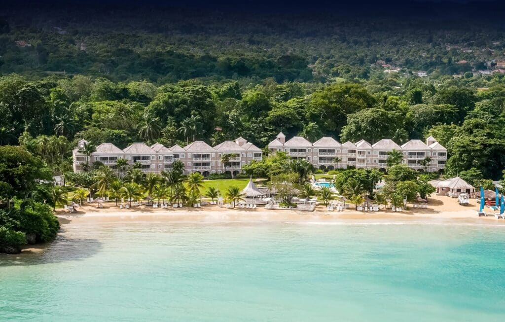 Vue aérienne d'un complexe hôtelier situé directement sur une plage de sable clair en Jamaïque.