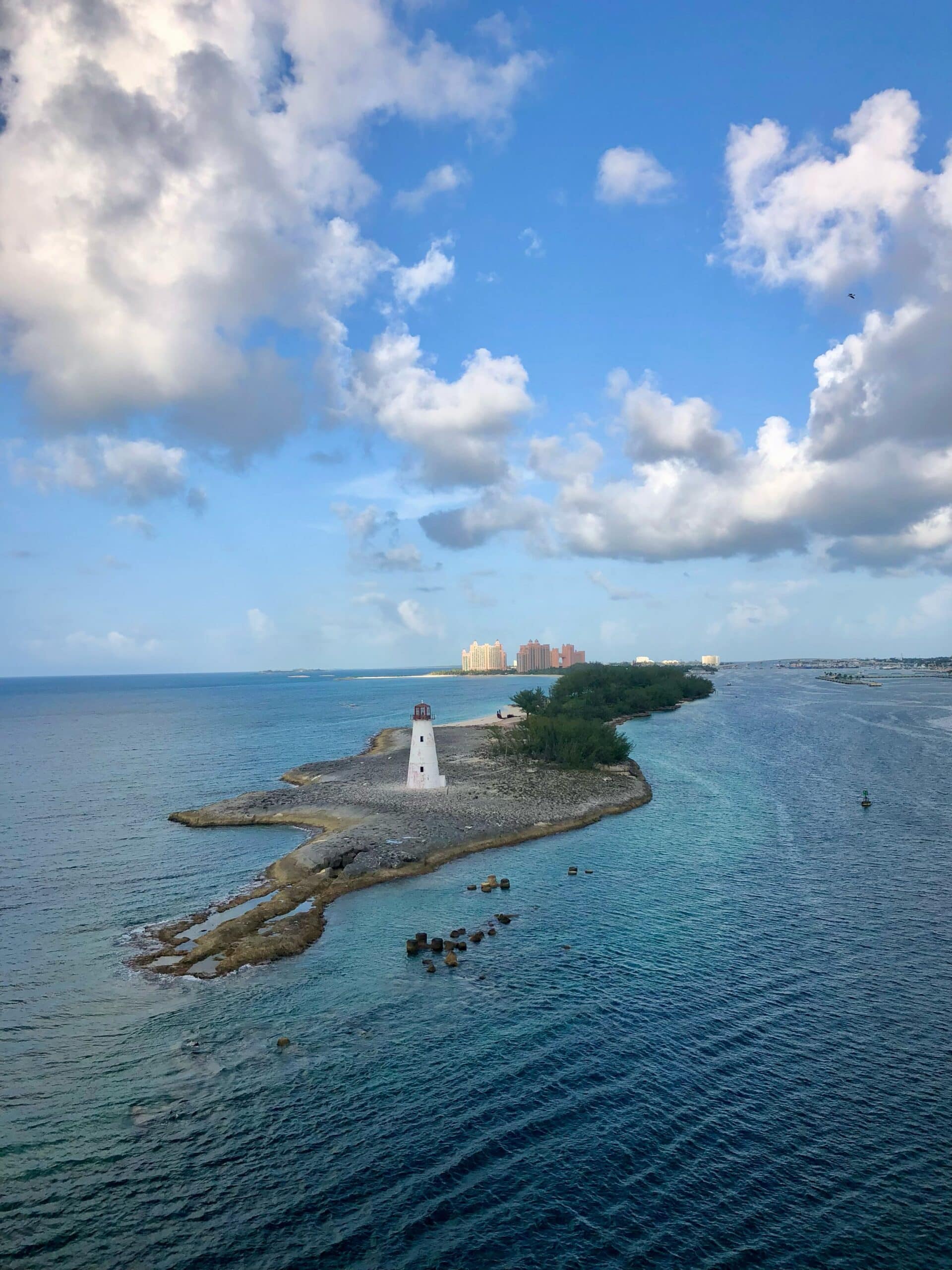 http://Phare%20blanc%20situé%20sur%20un%20petit%20îlot%20rocheux%20entouré%20par%20les%20eaux%20turquoise%20des%20Bahamas.