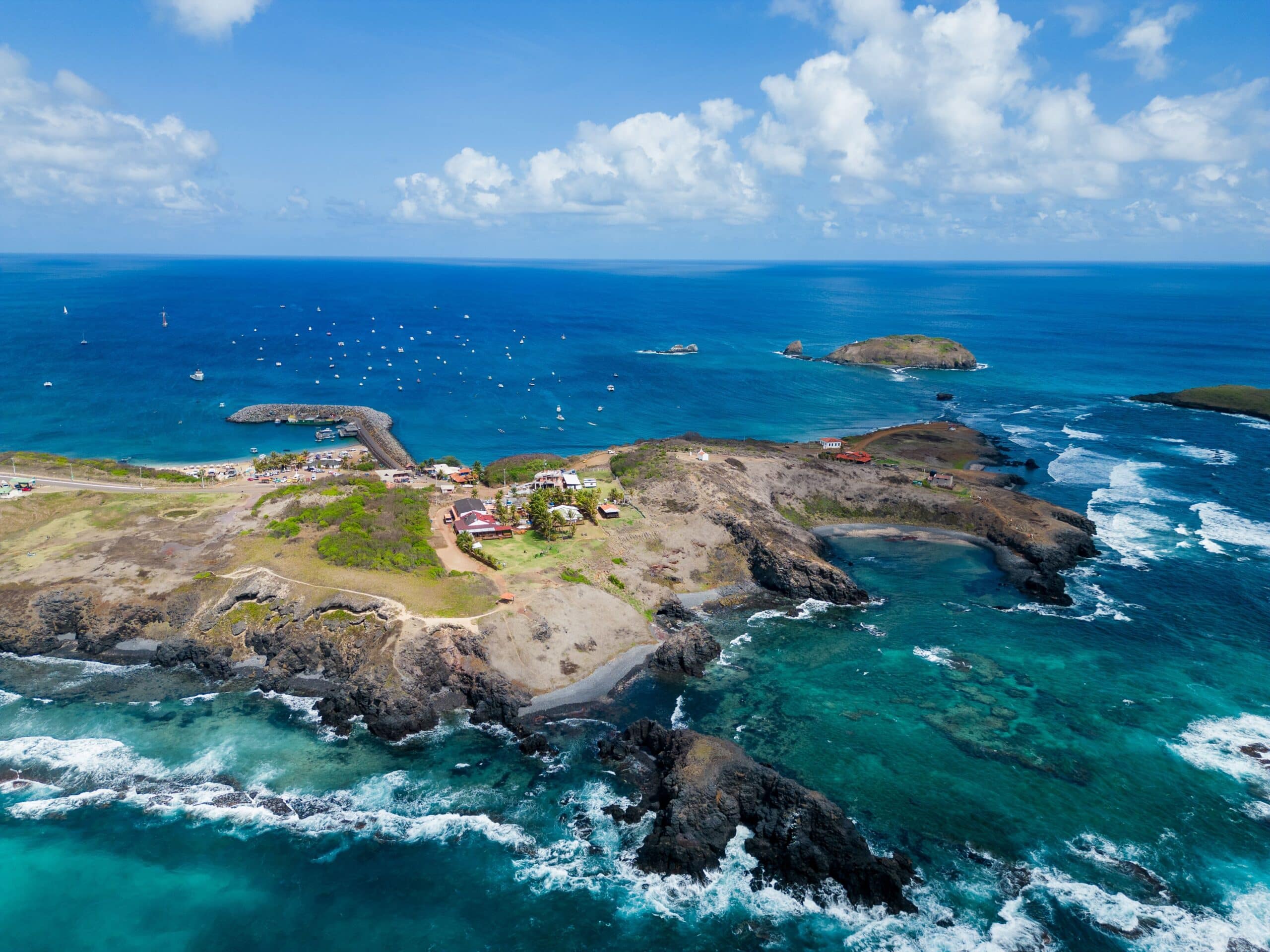 http://Vue%20aérienne%20d'une%20côte%20rocheuse%20entourée%20d'eaux%20turquoise%20avec%20petit%20port%20et%20îlots%20au%20large.