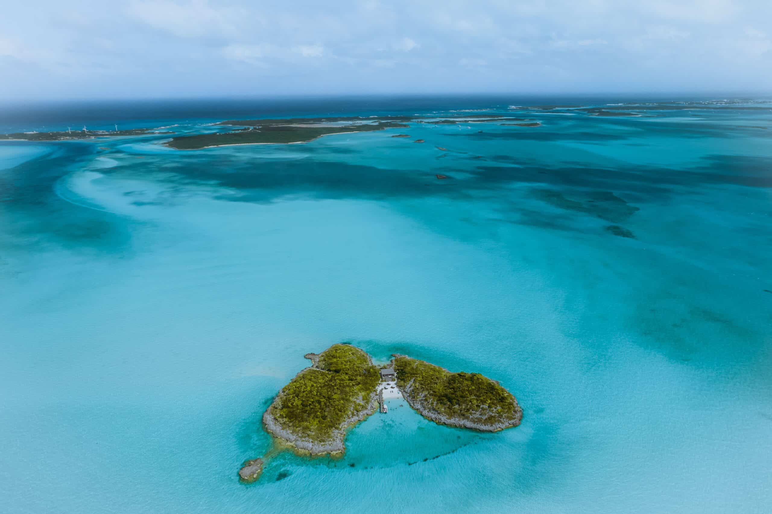 http://Vue%20aérienne%20d'un%20petit%20îlot%20entouré%20d'eaux%20turquoise%20et%20de%20lagons%20peu%20profonds%20aux%20Bahamas.