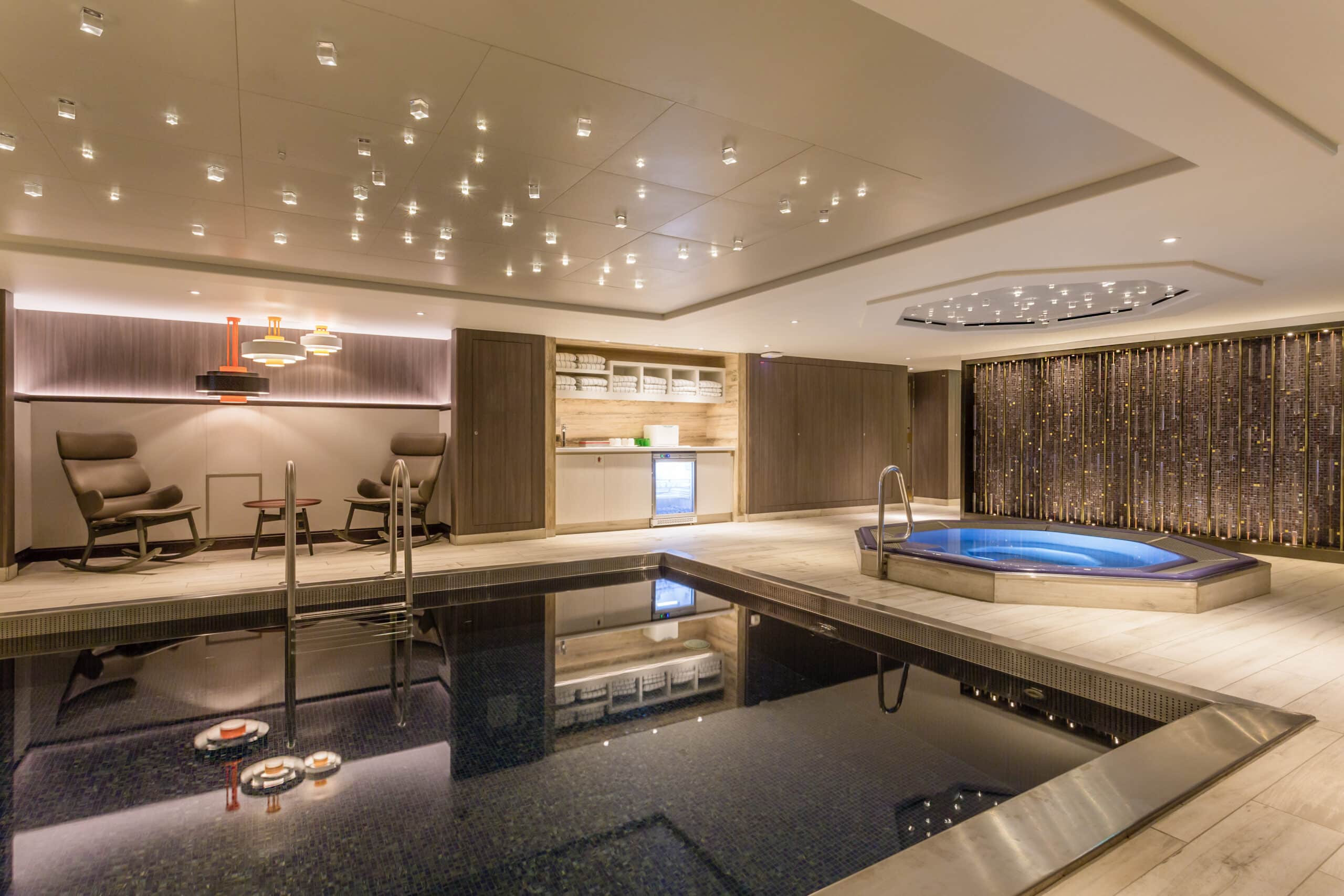 Piscine intérieure et jacuzzi avec espace de détente à bord d’un bateau de croisière fluviale.