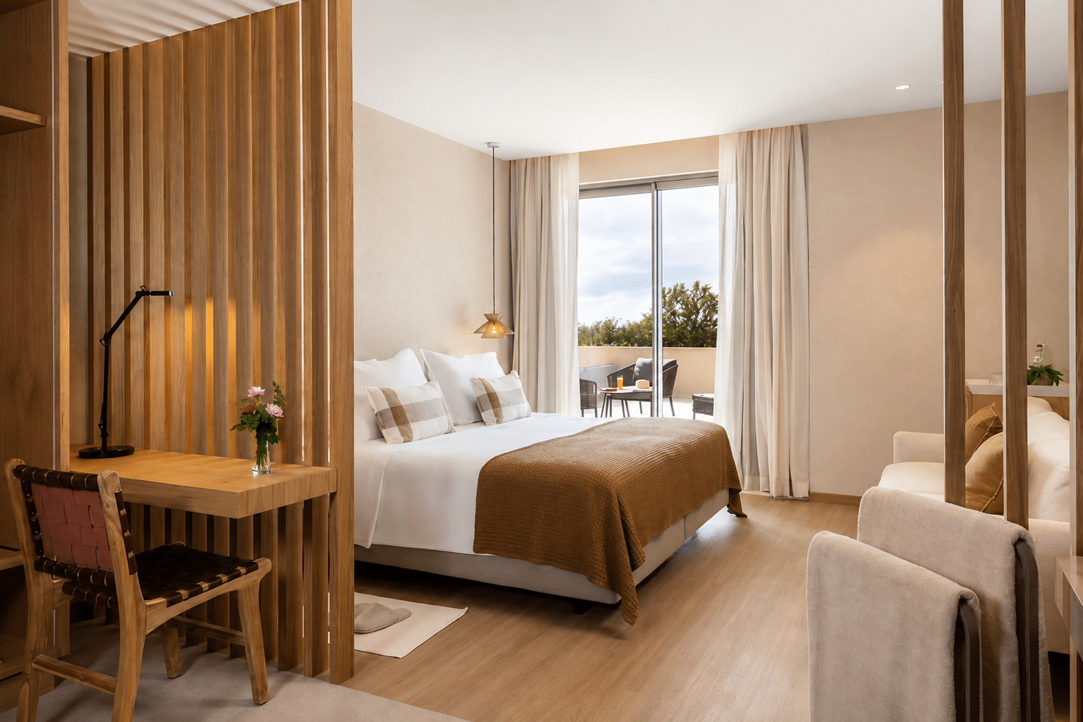 http://Chambre%20double%20moderne%20et%20lumineuse%20avec%20mobilier%20en%20bois,%20coin%20salon%20et%20terrasse%20extérieure%20aménagée.