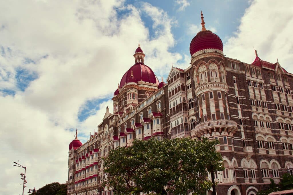 Façade de l'hôtel Taj Mahal Palace à Mumbai, reconnaissable à son architecture historique et à ses grands dômes rouges.