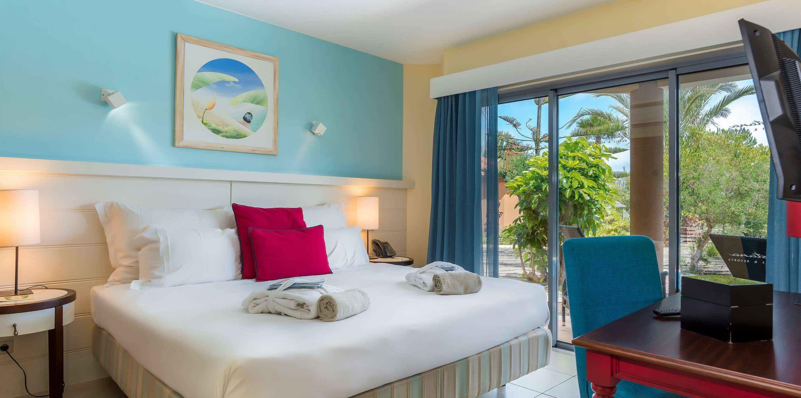 http://Chambre%20double%20lumineuse%20d’un%20hôtel%20à%20Porto%20Santo%20avec%20terrasse%20donnant%20sur%20un%20jardin%20tropical.