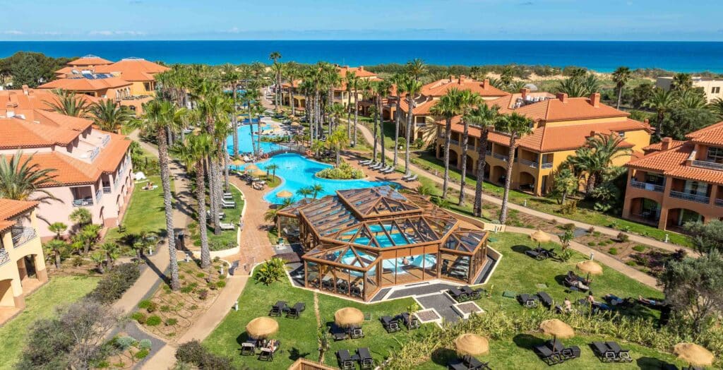 Vue aérienne d’un complexe hôtelier à Porto Santo avec piscines, palmiers et jardins à proximité de l’océan Atlantique.