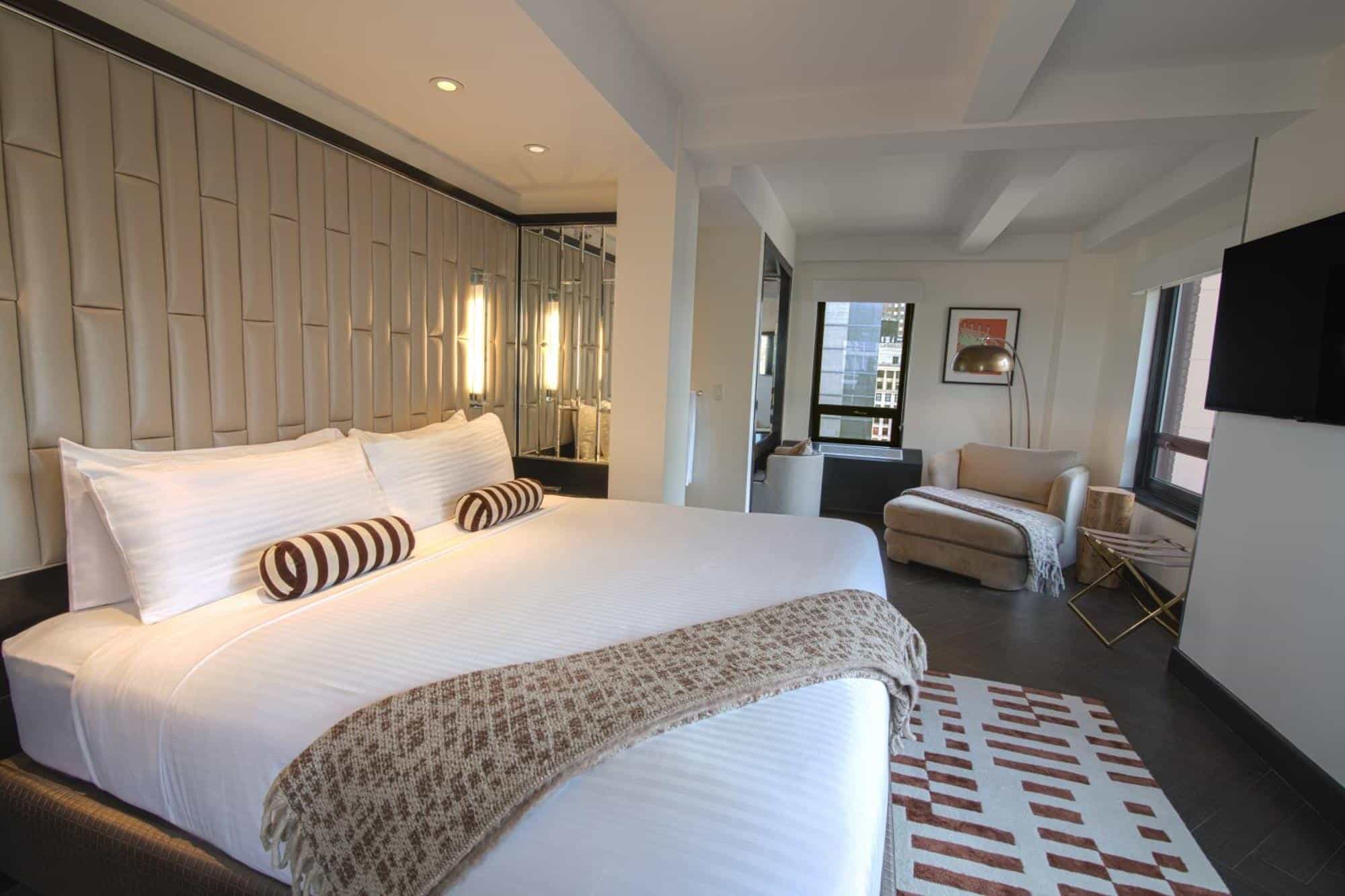 http://Chambre%20d’hôtel%20moderne%20à%20New%20York%20avec%20grand%20lit,%20coin%20salon%20et%20décoration%20contemporaine.