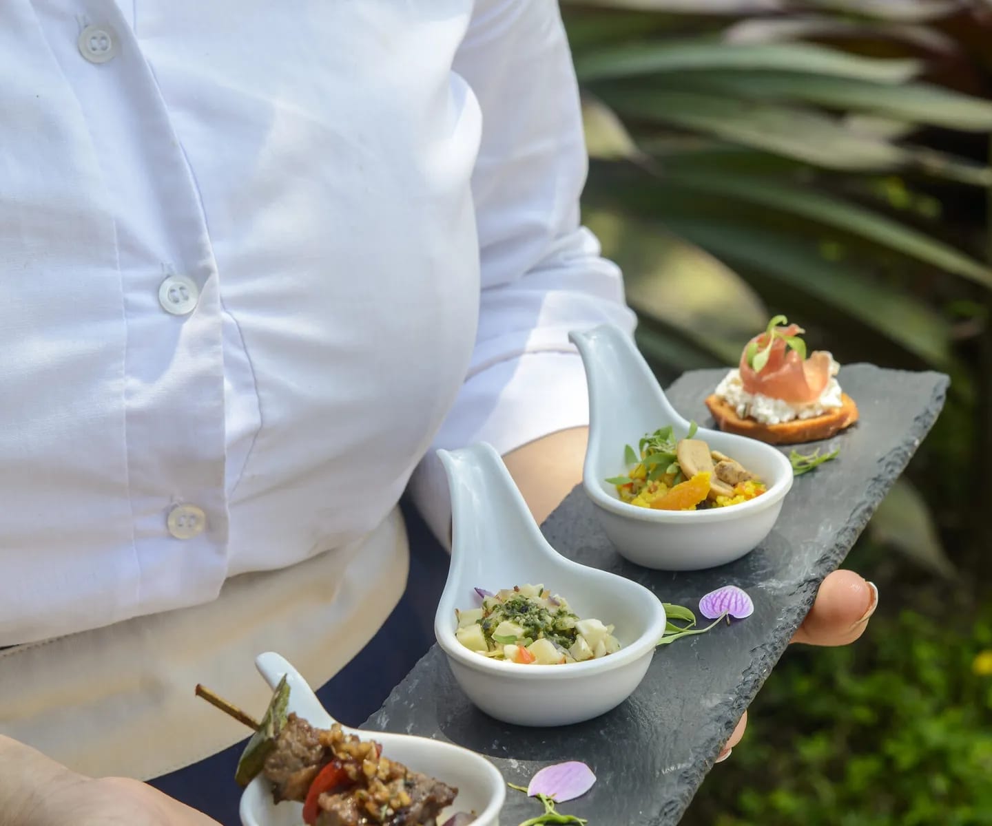 http://Serveuse%20présentant%20une%20sélection%20de%20bouchées%20et%20spécialités%20gastronomiques%20dans%20un%20hôtel%20au%20Brésil.