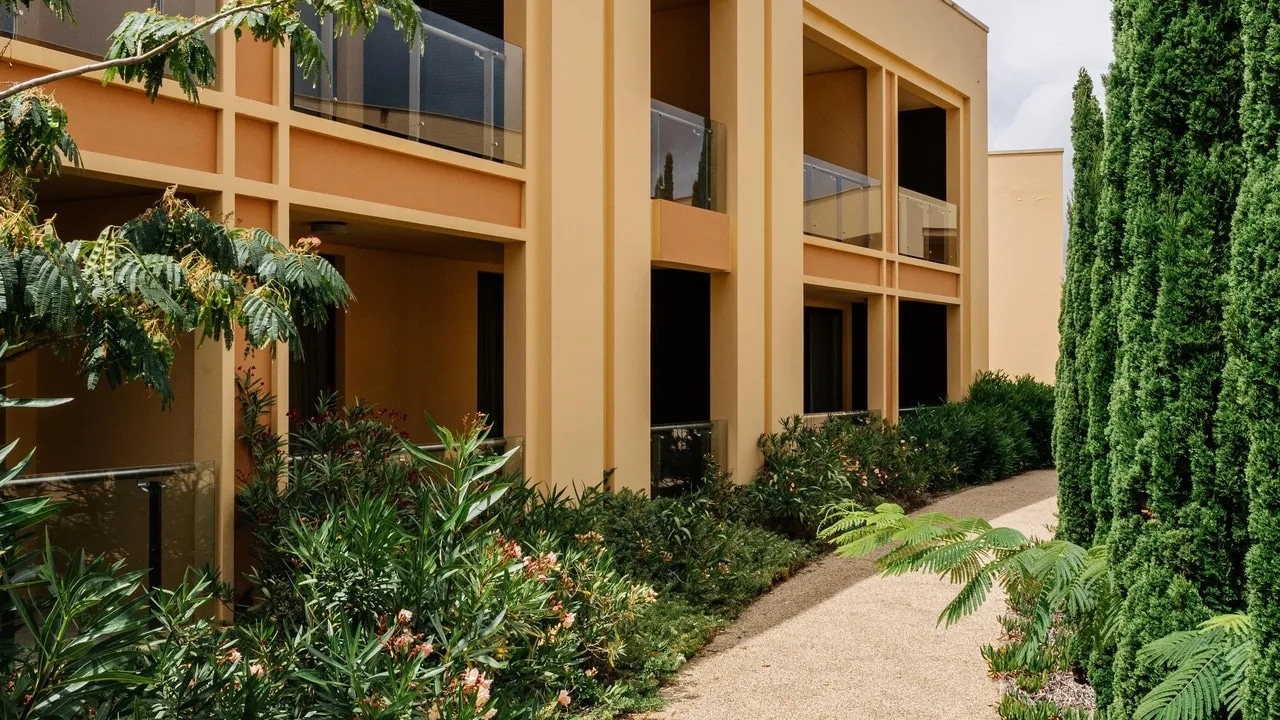 http://Façade%20d’un%20hôtel%20à%20Porto%20Santo%20avec%20balcons%20donnant%20sur%20un%20jardin%20arboré%20et%20une%20allée%20paysagère.