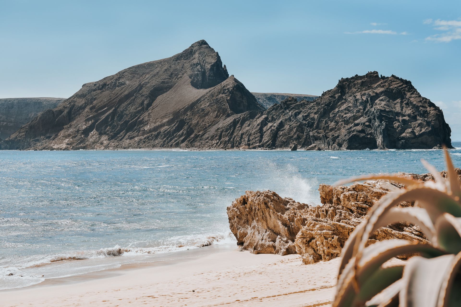 Plage de sable doré de Porto Santo avec les rochers volcaniques du Pico de Ana Ferreira en toile de fond.
