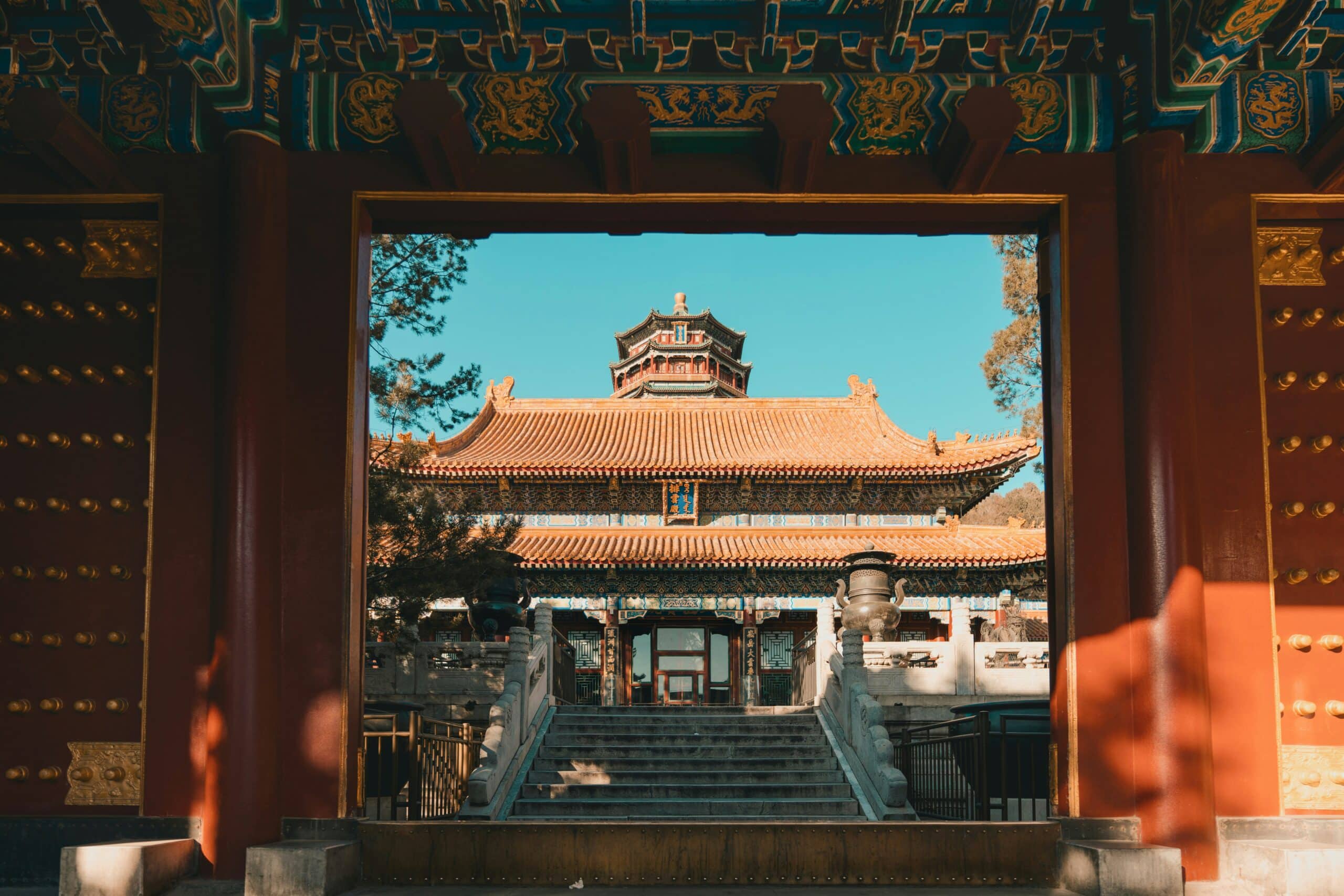 http://Pavillon%20traditionnel%20chinois%20aux%20toits%20ornés,%20encadré%20par%20une%20porte%20monumentale%20rouge.
