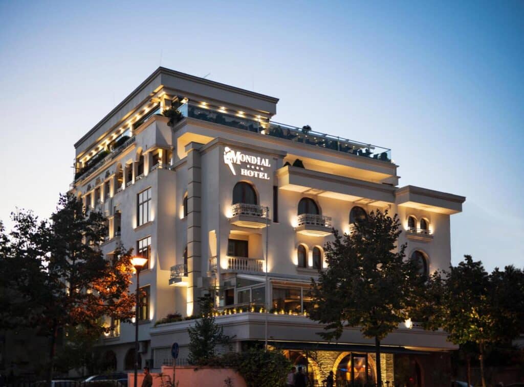 Façade illuminée du Mondial Hotel à Tirana en Albanie à la tombée de la nuit.