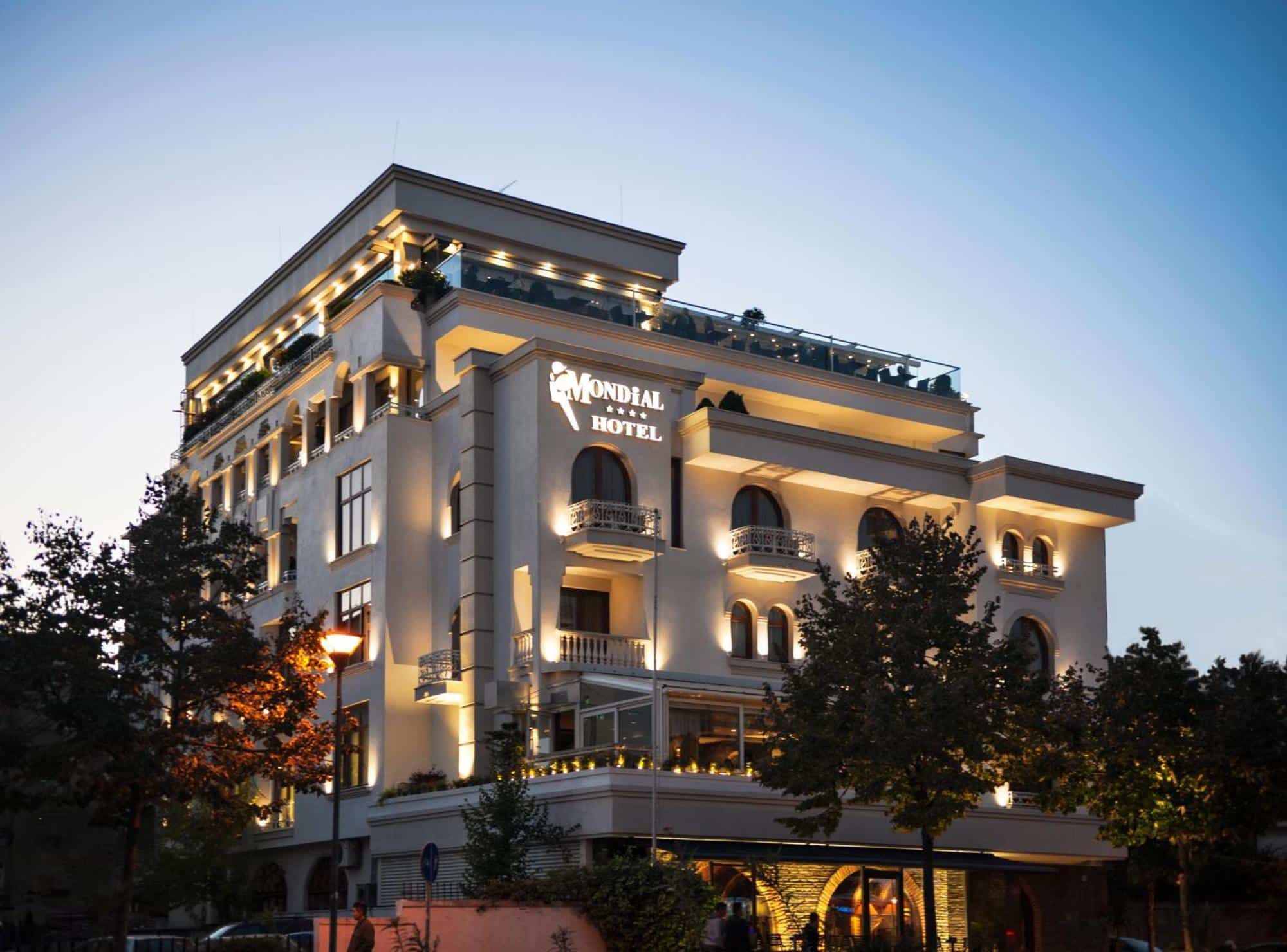 Façade illuminée du Mondial Hotel à Tirana en Albanie à la tombée de la nuit.