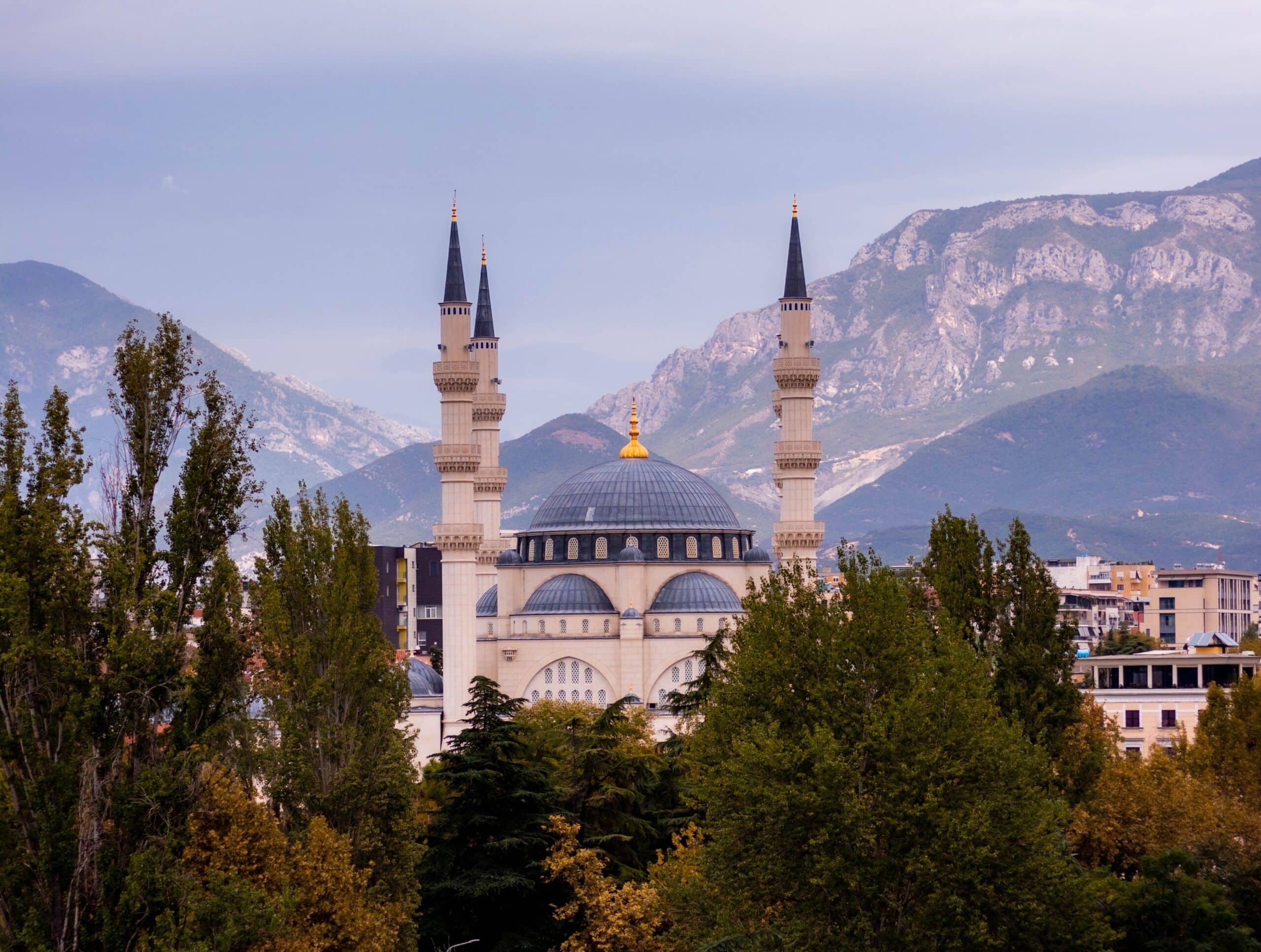 Mosquée à Tirana avec son dôme et ses minarets devant les montagnes albanaises.