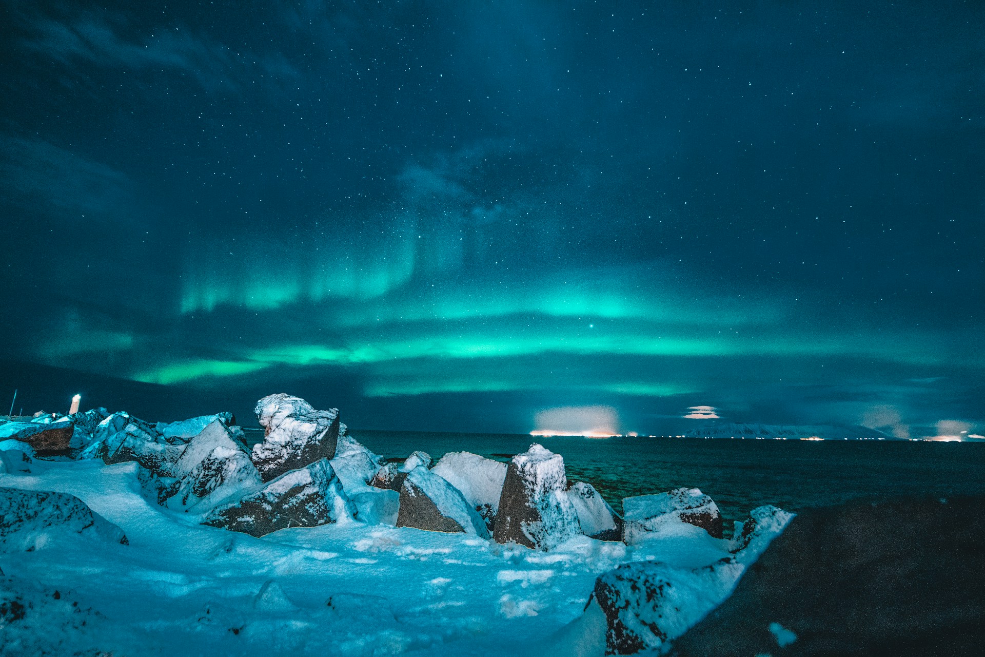 Aurores boréales vertes illuminant le ciel nocturne au-dessus d'un paysage volcanique islandais.