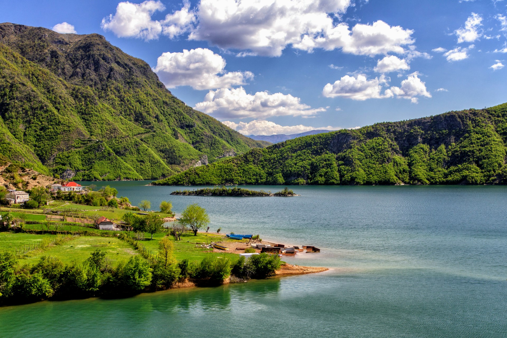 L'île de Shurdhah sur le lac Koman en Albanie, avec ses ruines d'une cité médiévale immergée entourées d'eaux émeraude.
